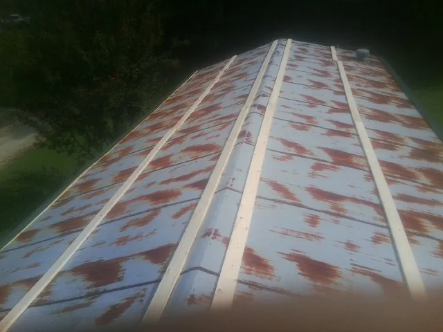 Rusted metal roof panels with new wood purlins before replacement — Storm Damage Roof Repair in Collettsville by Roofing Brothers