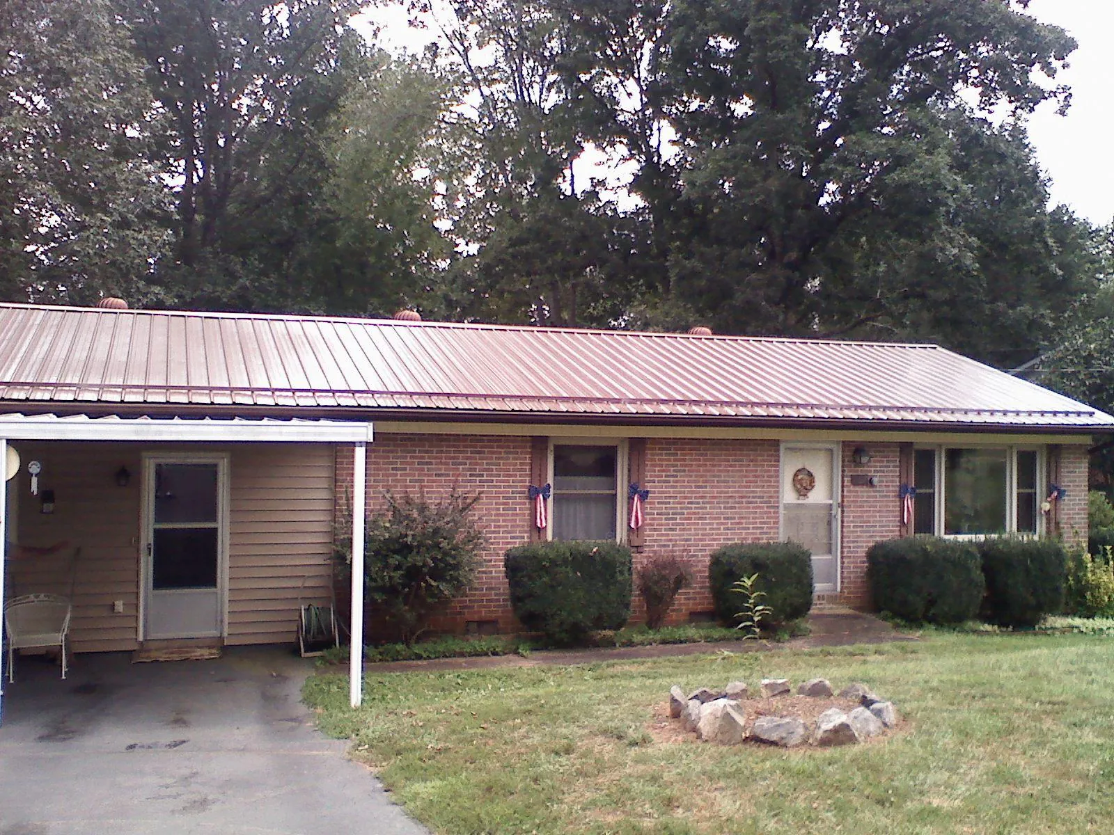 Bronze metal roof and carport on a brick ranch home — Roof Repair work by our crew in Collettsville